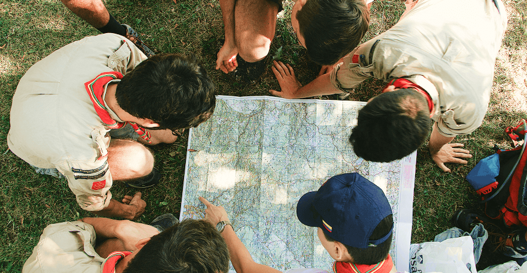 仲間で地図を囲んで進路を相談するイメージ