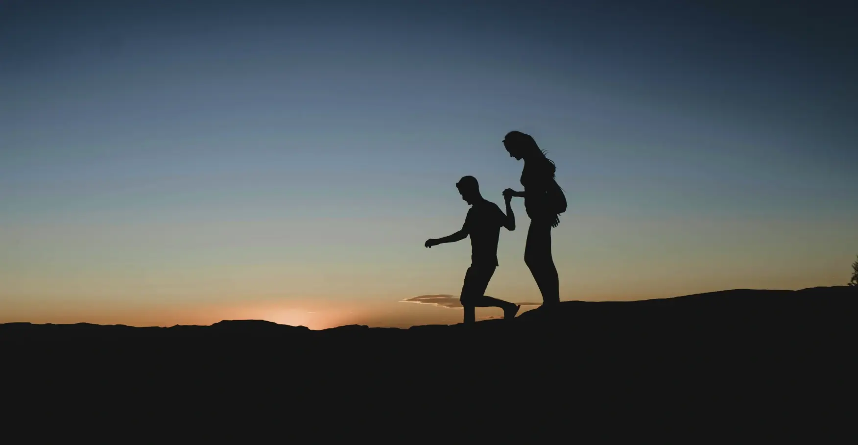 夕暮れに寄り添って歩く二人のシルエットのイメージ
