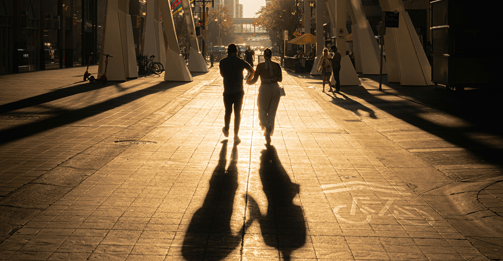 夕暮れの街を並んで歩く二人のシルエットのイメージ