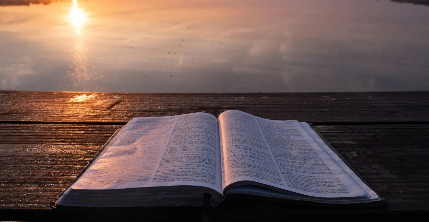 朝焼けの湖畔に置かれた開いた本