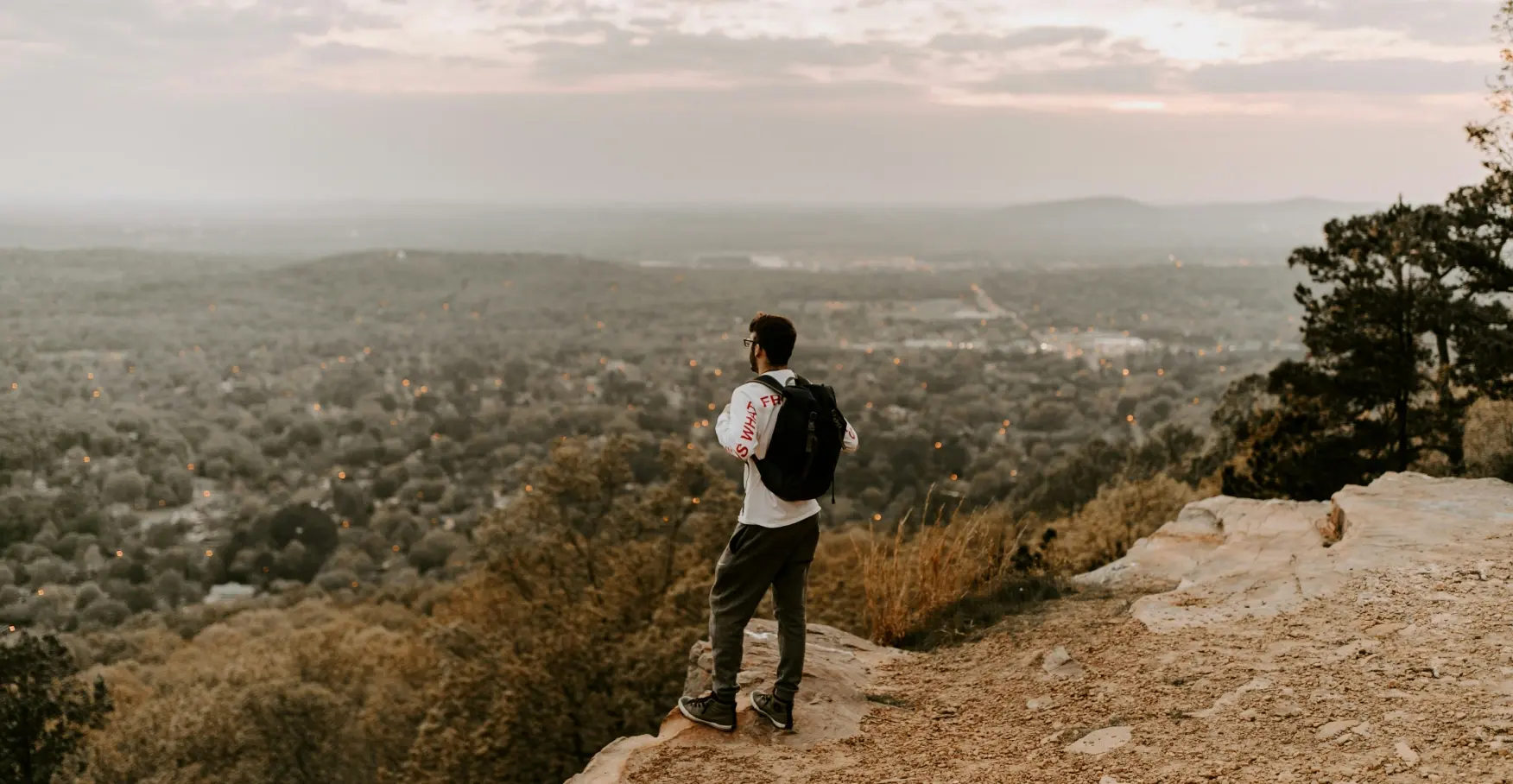 山頂から街並みを見渡す人物のイメージ