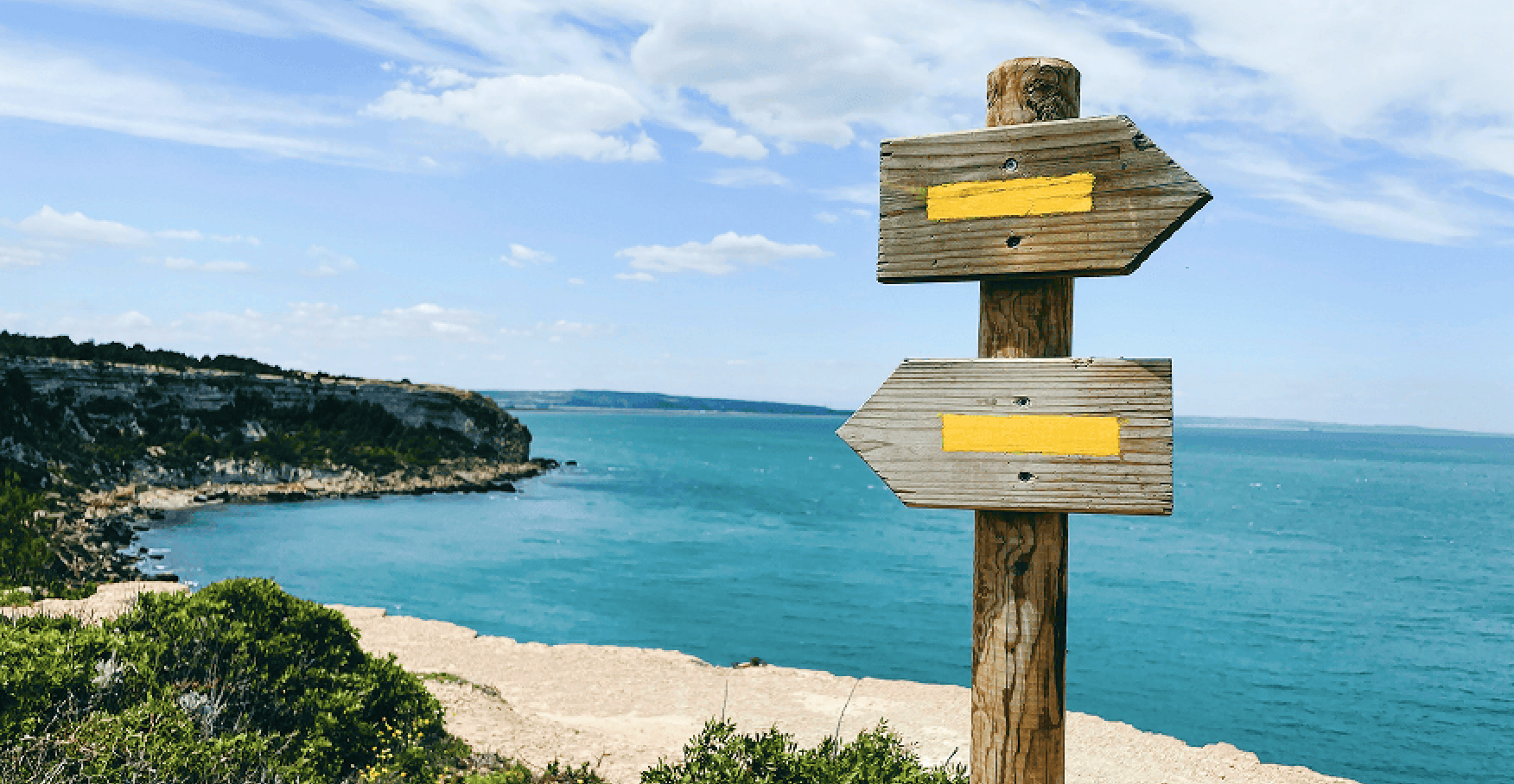 海沿いの岬に立つ矢印の道標のイメージ