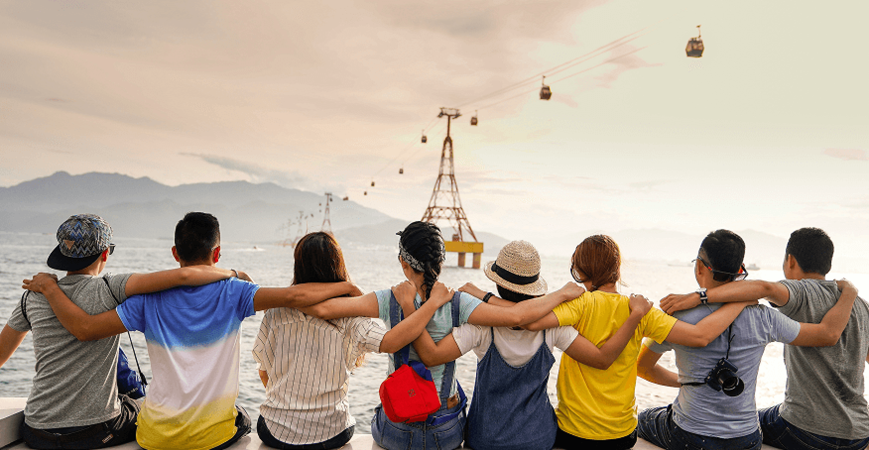 海辺で仲間同士が肩を組んで並ぶ様子のイメージ