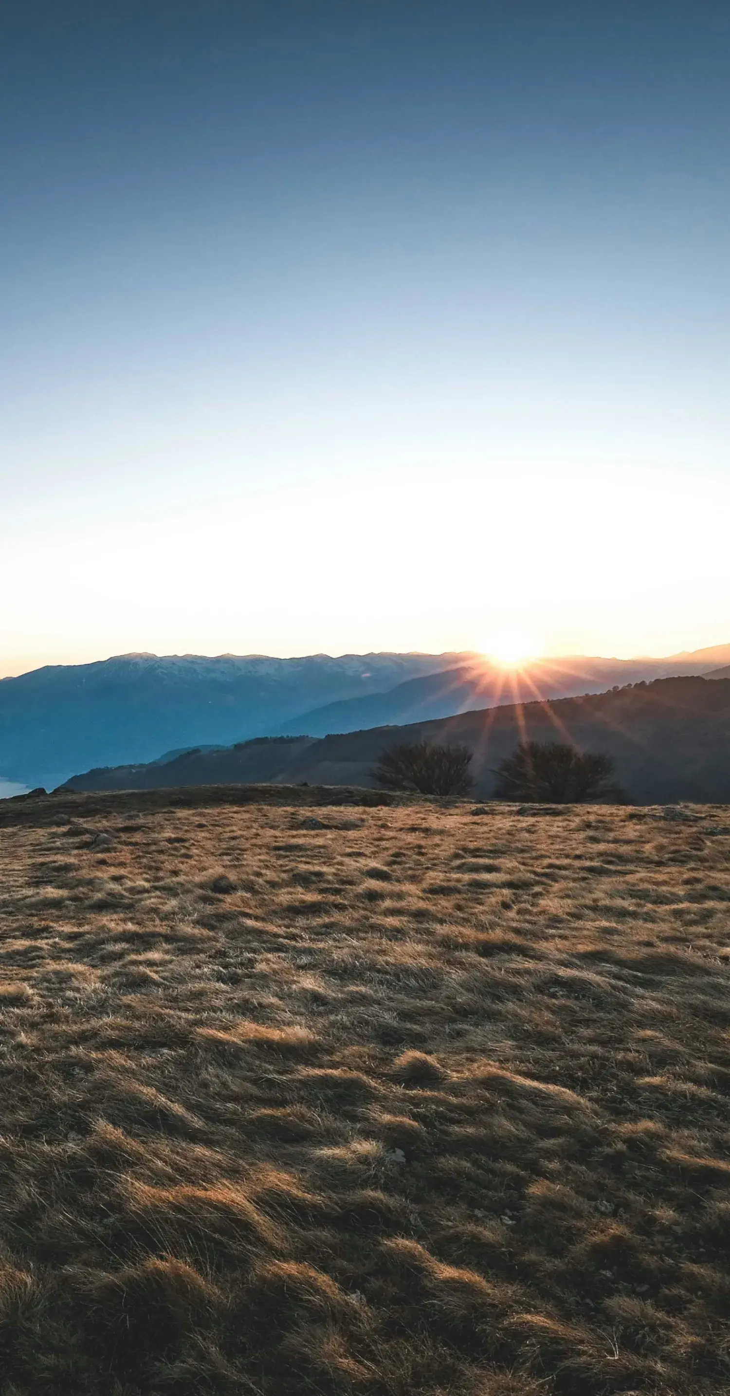 山脈から昇る朝日と、眼下に広がる湖の風景_メインビジュアル_sp