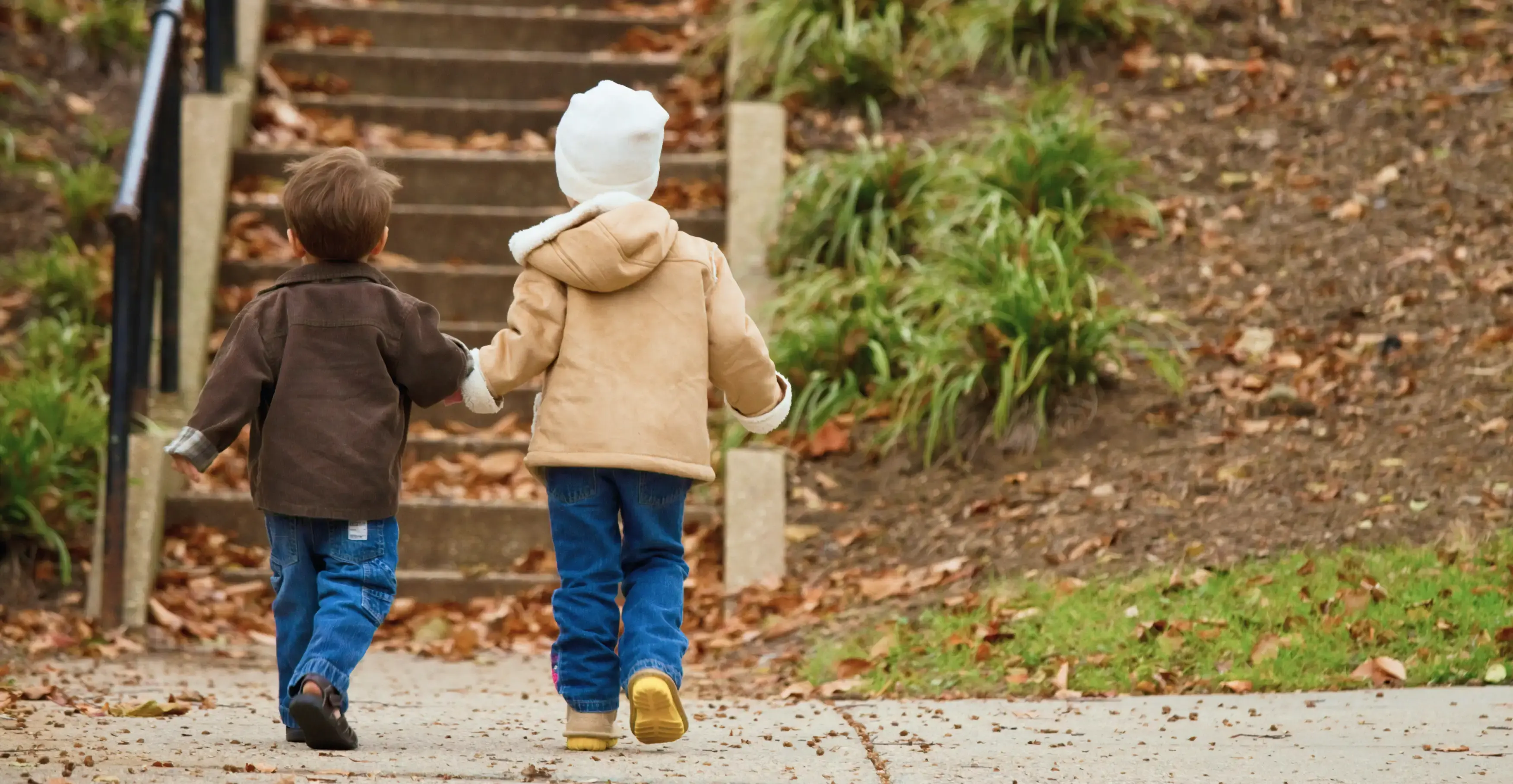 手をつないで歩く二人の子供の後ろ姿