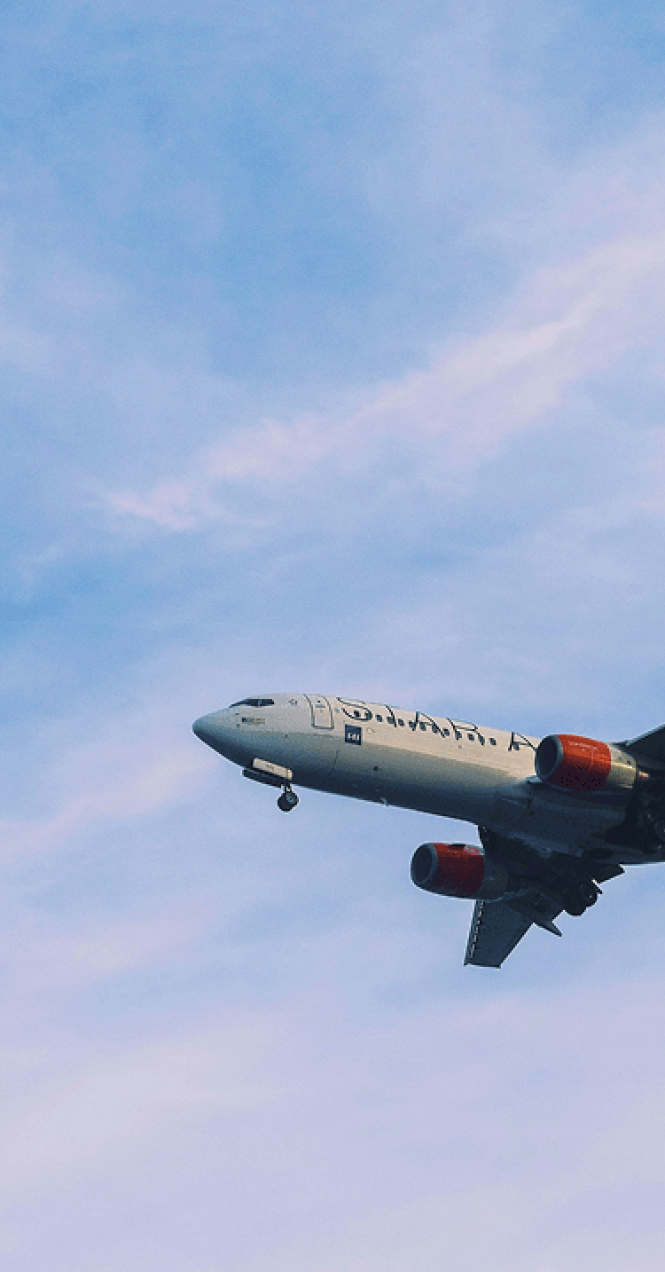 青空の中を飛ぶ飛行機のイメージ